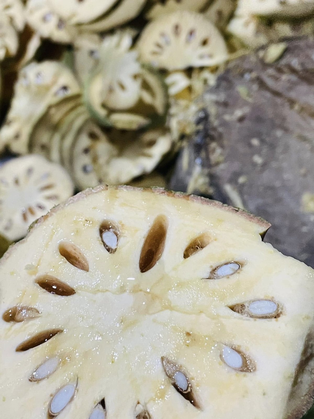 A young fruit cut open: pale pulp, seeds in clear mucilage