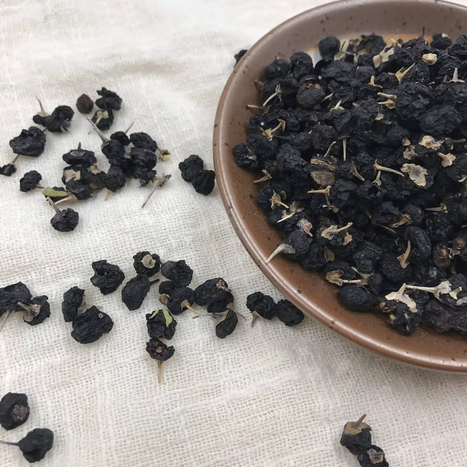Dried berries, each with its pale stalk and papery calyx